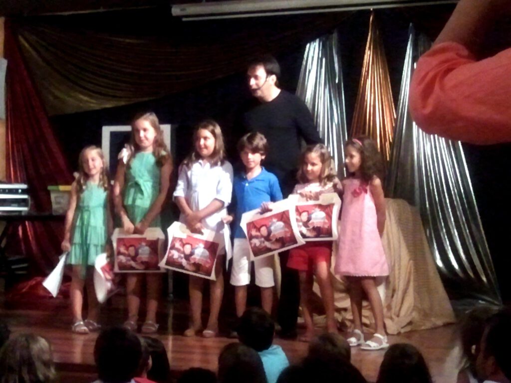 Niños en actividad mágica sobre escenario profesional.